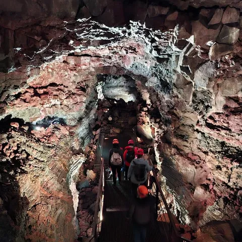 Visitors walking through the Raufarholshellir lava tunnel