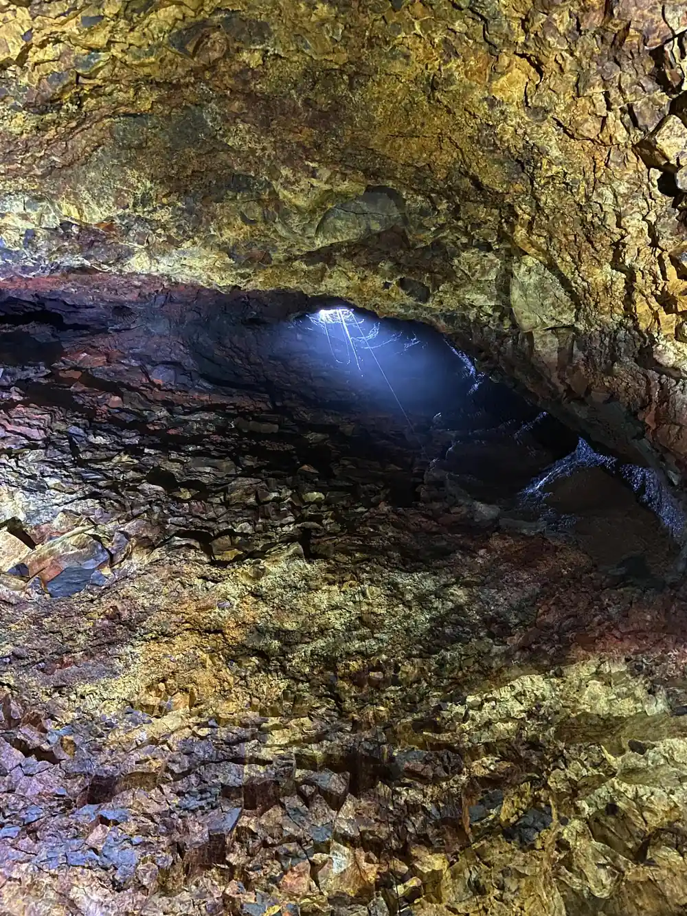 The chamber roof arching over the rubble with light from the shaft