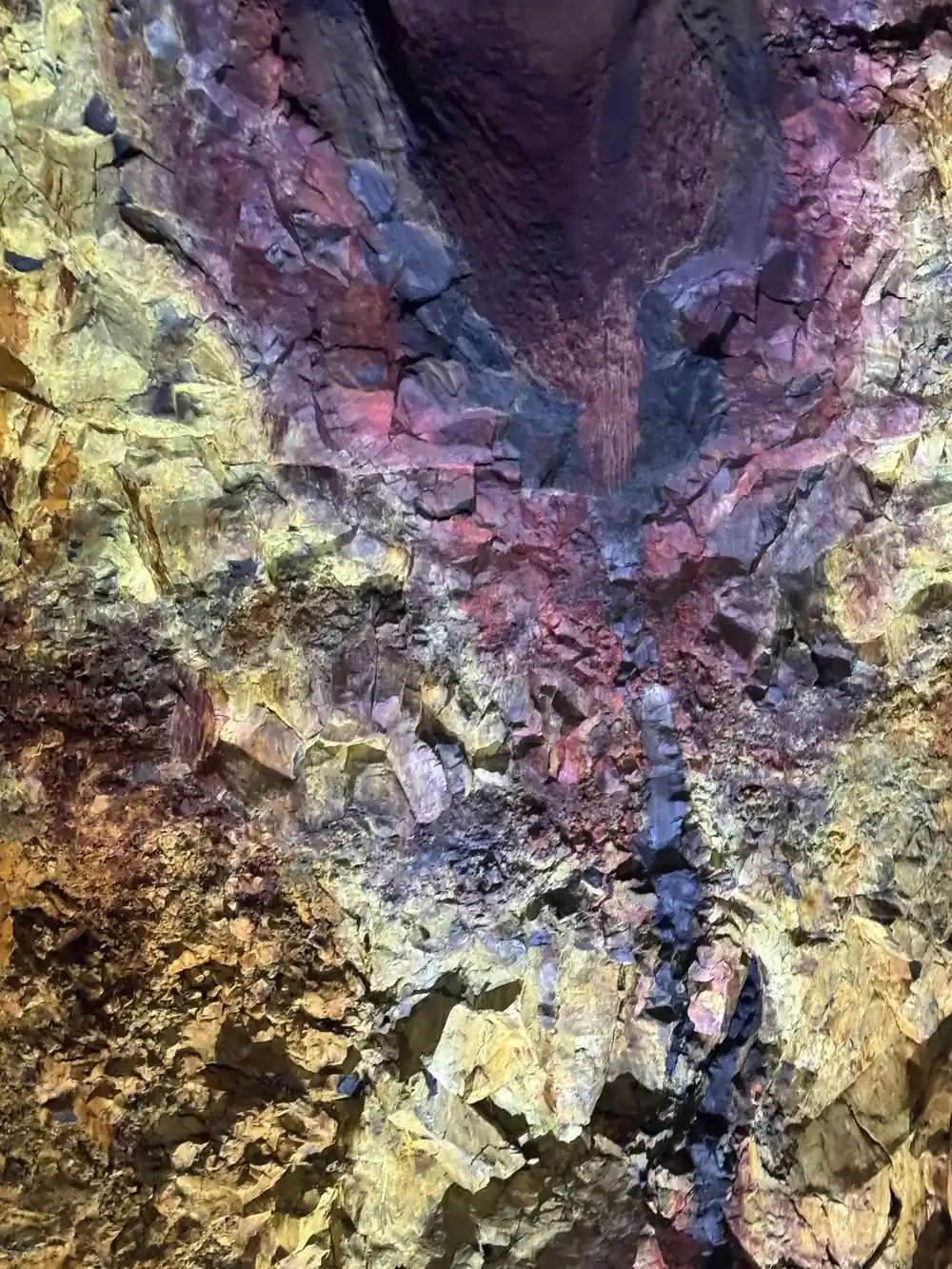 The chamber wall in violet and gold above the rubble slope