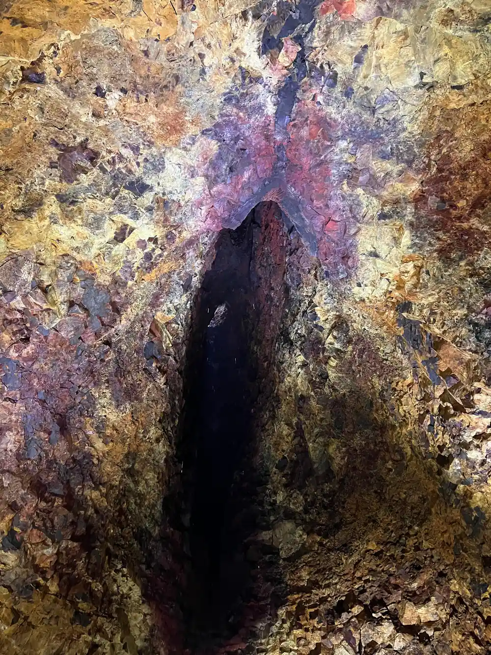 A dark vertical fissure running up the coloured wall