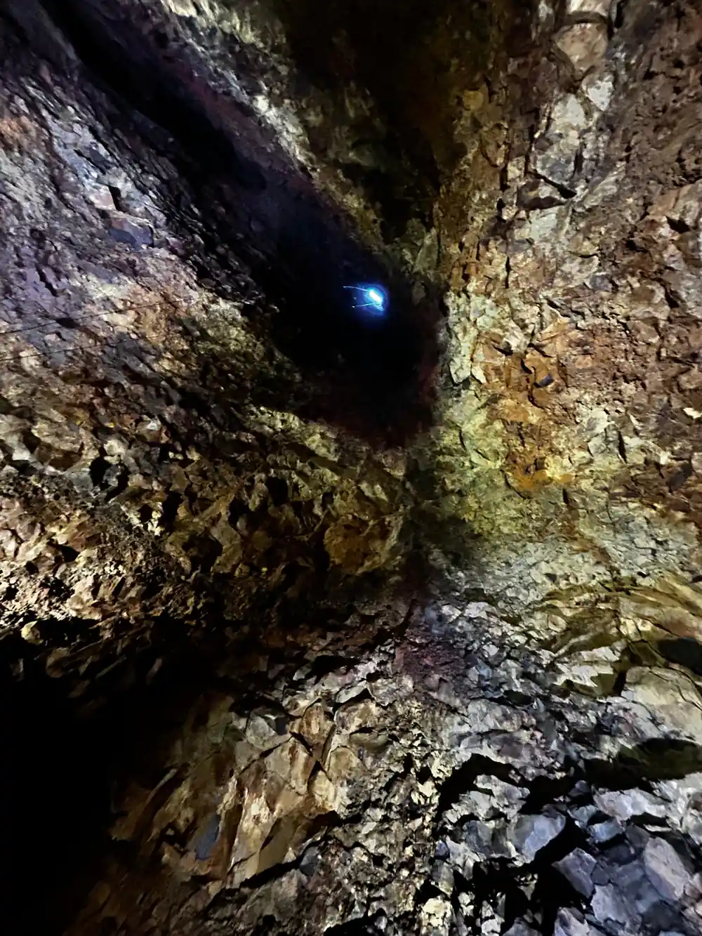 A lamp set into the rock with gold walls curving away