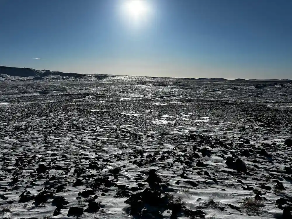 The lava field under low sun with the path running out across it