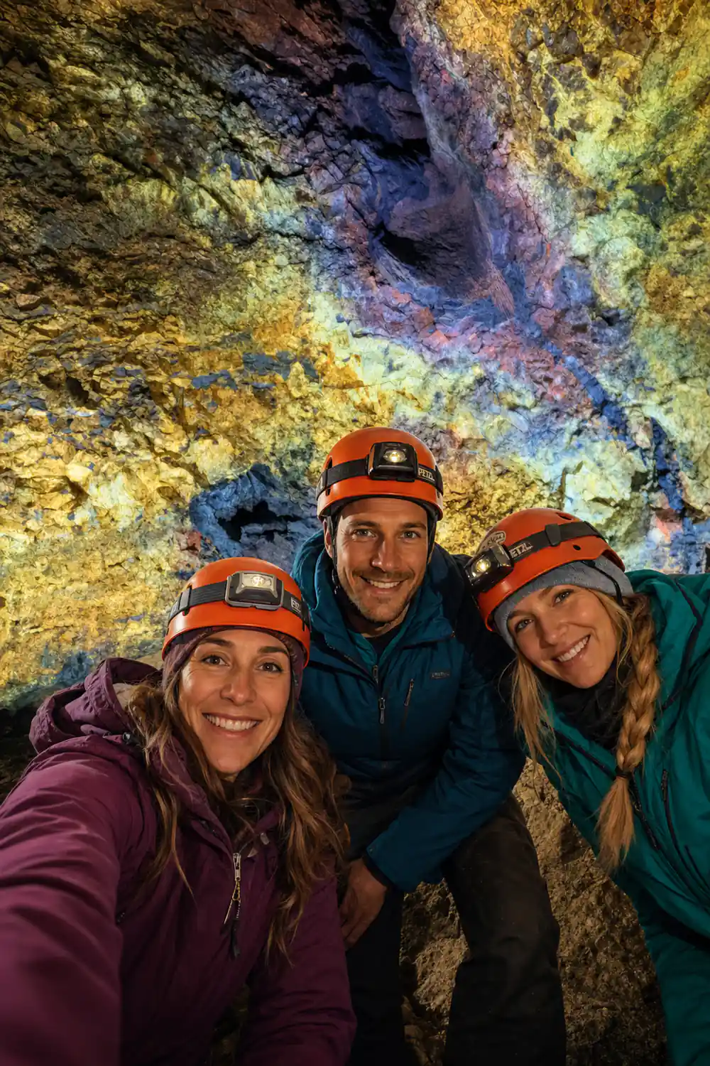 Three visitors in helmets under the brightest part of the roof