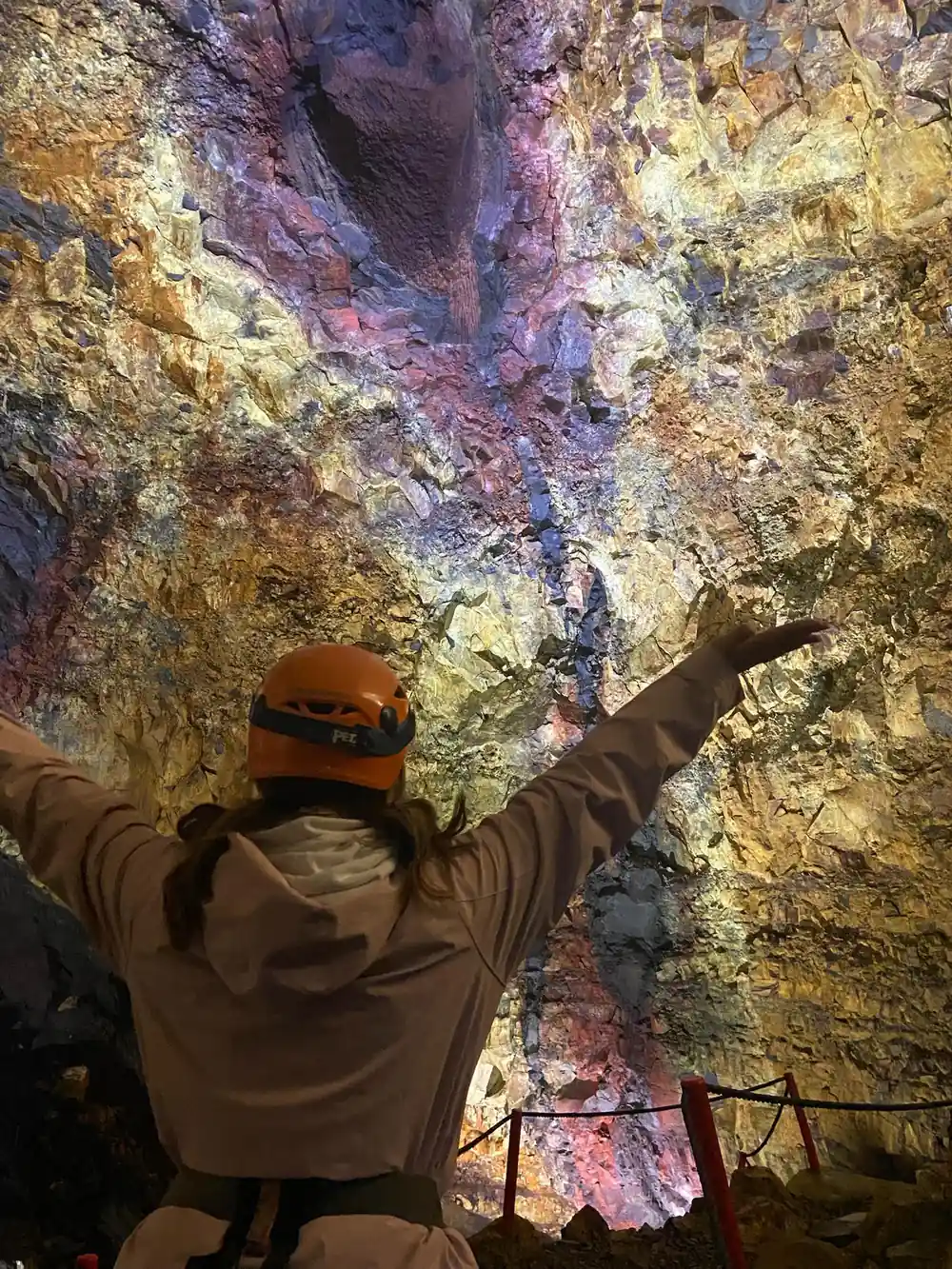 A visitor with arms spread against the full width of the chamber wall