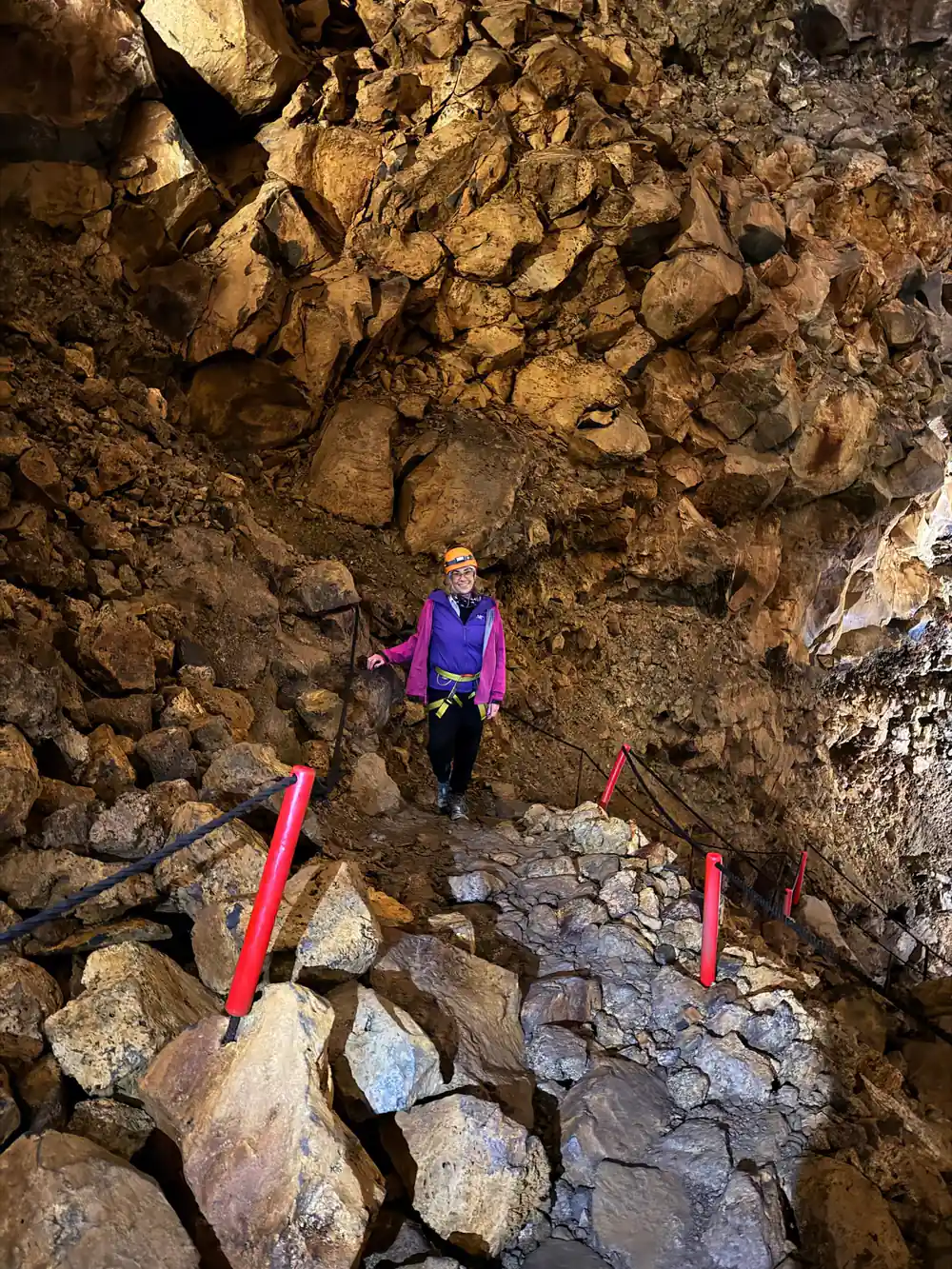 A visitor descending the rubble slope between marker poles