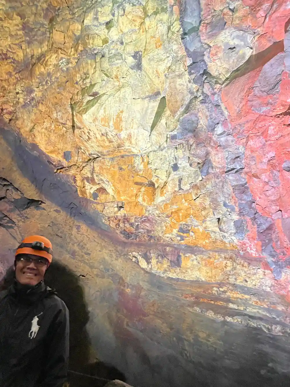 A visitor small against a vast orange and yellow wall